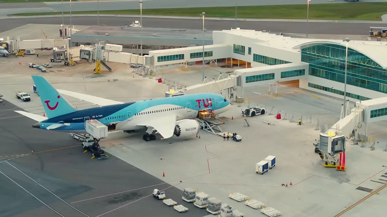 TUI Boeing 787 Dreamliner at the gate at Melbourne Orlando International Airport (MLB), Florida, with jet bridge in position and ground crew vehicles on the apron