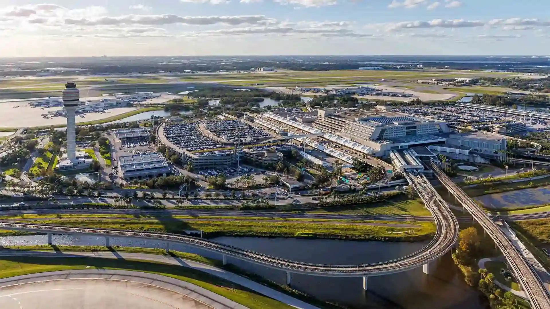 Aerial view of Orlando Airport (MCO) showing the main terminal and adjacent parking garages used for UK holidaymaker car hire collections.